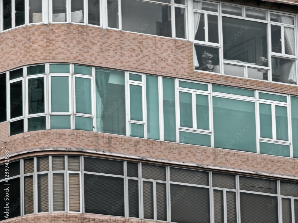 Aufkleber a close-up view of a building's facade, showcasing a repeating pattern of windows with teal-colored 