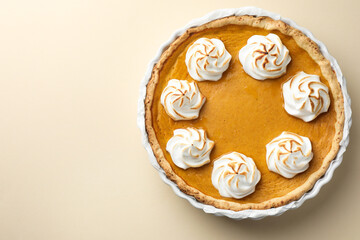 Tasty homemade pumpkin pie in baking dish on beige table, top view. Space for text