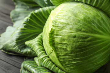 Fototapeta premium One ripe head of cabbage on black wooden table, closeup