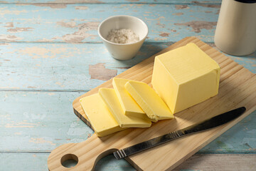 Butter block, grass-feed butter slices over wood cutting board. Vitamin D and source of fat 