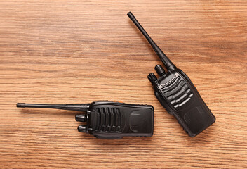 Walkie talkies on wooden table, top view