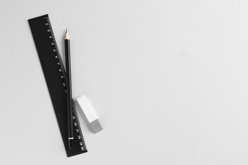 Ruler, pencil and eraser on light grey background, flat lay. Space for text