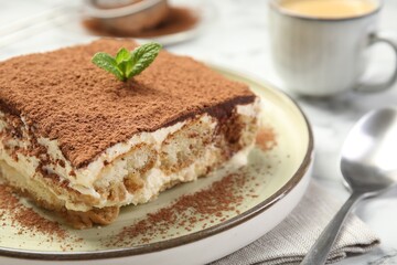 Piece of tasty tiramisu on white table, closeup