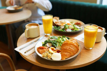 Woman having tasty breakfast in cafe, focus on different meals and coffee