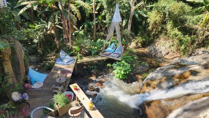 Serene Outdoor Retreat by Flowing Stream Surrounded by Lush Greenery