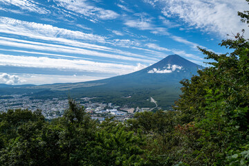 Fototapeta premium Breathtaking panoramic view of Mount Fuji, Japan, with a vibrant blue sky and lush green surroundings.