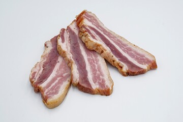 Pieces of salted lard with layers of meat on a white background. Sliced ​​bacon.
