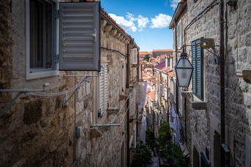 Charming narrow street in a historic town with stone buildings and laundry hanging between them.