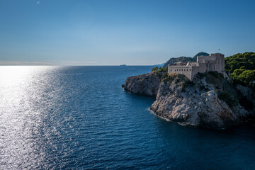 Majestic medieval fortress perched dramatically on a cliff overlooking the serene Adriatic Sea.