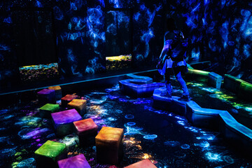 Person exploring an immersive digital art installation featuring glowing jellyfish and colorful...
