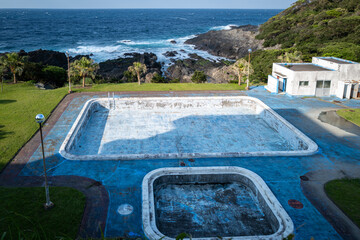 Serene coastal scene of an abandoned pool overlooking the ocean