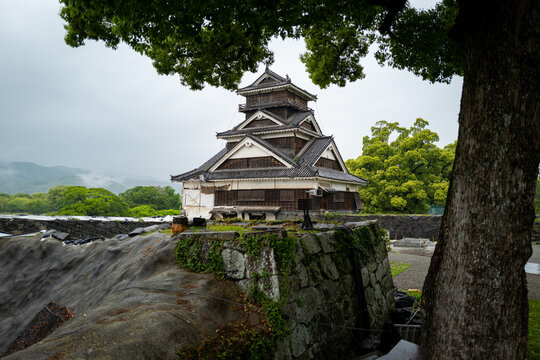 An ancient Japanese castle majestically overlooks a tranquil landscape, its aged wooden structure a stunning sight.