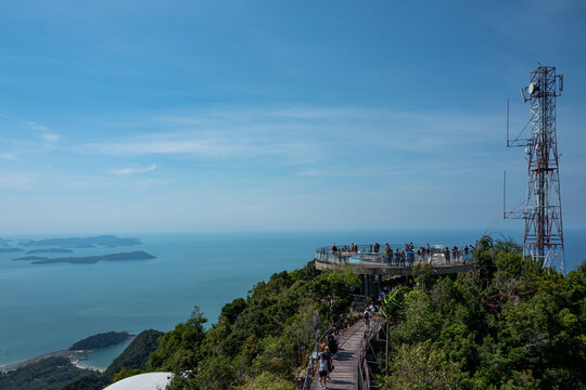 A breathtaking view of the ocean and islands from a mountaintop viewpoint. People gather to enjoy the stunning coastal scenery.
