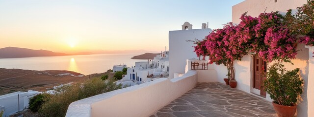 Fototapeta premium A tranquil sunset casts golden light over the island of Santorini. Bougainvillea blooms adorn a terrace, revealing classic white buildings against the sea