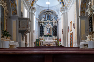 Serene church interior with an ornate altar and rows of wooden pews, creating a peaceful atmosphere.