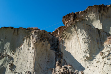 A captivating view of unique rock formations, sculpted by erosion under a clear, vibrant blue sky.
