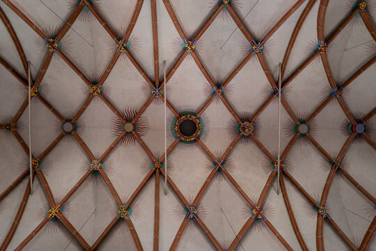 Intricate Painted Ceiling with Wooden Beams and Radiant Sunbursts in Geometric Pattern. - Powered by Adobe