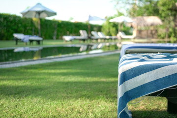 Deckchairs covered with towel. By the poolside. Vacation or holiday concept.
