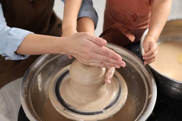Hobby and craft. Mother with her daughter making pottery indoors, closeup