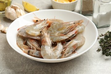 Fresh raw shrimps and spices on grey table, closeup