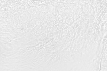 White water with ripples on the surface. Defocus blurred transparent white colored clear calm water surface texture with splashes and bubbles. Water waves with shining pattern texture background.