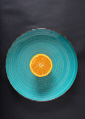 Chopped orange served on a blue plate with a clean background, attractive presentation with room...