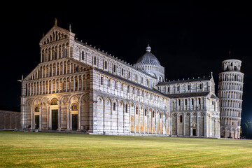Majestic Pisa Cathedral and Leaning Tower at night, beautifully lit against the dark sky. A serene...
