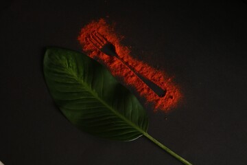 Conceptual image of condiments and kitchen fork, tropical green leaf
