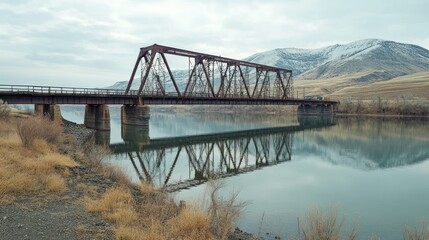 Rusty railroad bridge reflecting in calm river.