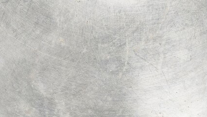 close-up of a scratched metal surface, possibly stainless steel or aluminum. The texture is rough, with numerous fine and deep scratches crisscrossing in various directions, creating a worn and aged a