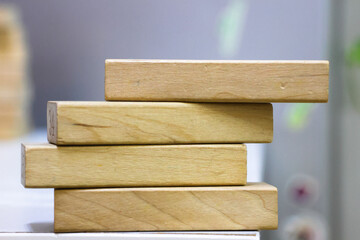 A pile of four wooden blocks on the soft white background.
