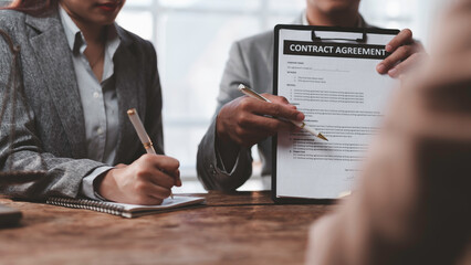 Business partners reviewing contract agreement terms and conditions