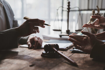 Lawyers discussing contract during meeting in courtroom with gavel and scales of justice