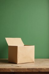 A partially opened empty cardboard box sits on a rustic wooden surface against a muted green backdrop.