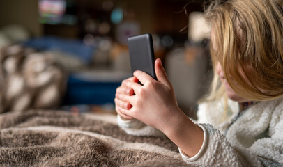 Young girl using an e-reader tablet to enjoy a book. © Lost_in_the_Midwest