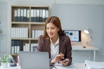 Asian businesswoman using calculator and laptop working in office