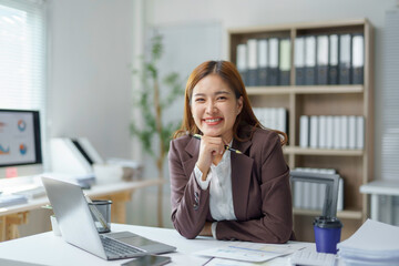 Asian businesswoman smiling and working in modern office