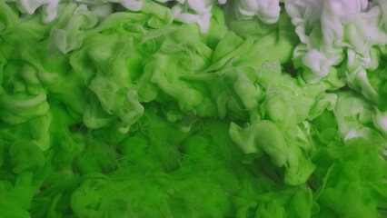 Liquid dye. Water ink surface. Defocused green white color haze cloud vapor texture paint fluid flow on abstract art light background.