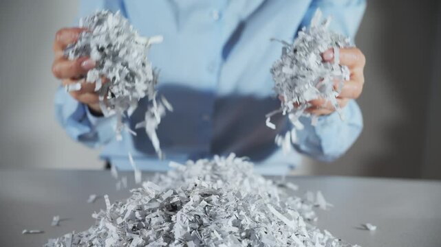Shredded paper office documents in worker woman hands. Close up