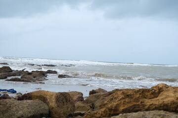Scenic Rocky Beach with Waves and Cloudy Sky