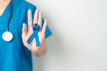March Colorectal Cancer Awareness month, doctor with dark Blue Ribbon for supporting people living and illness. Healthcare, hope and World cancer day concept
