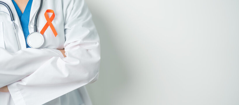 Doctor with Orange Ribbon for Leukemia, Kidney cancer day, world Multiple Sclerosis, CRPS, Self Injury Awareness month. Healthcare and word cancer day concept - Powered by Adobe