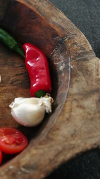 Pizza dough with vegetables and spices on wooden tray