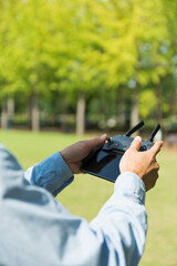 公園でドローンを飛ばす40代男性