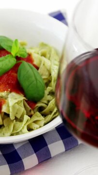 Glass of red wine with cooked pasta