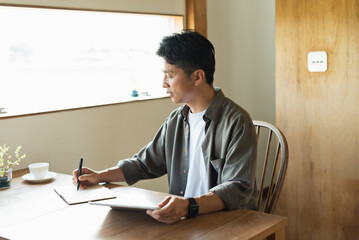カフェで仕事をする40代男性