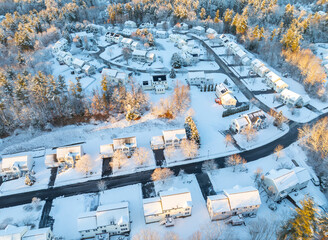 aerial view of residential community in winter after snow under dusk sunlight