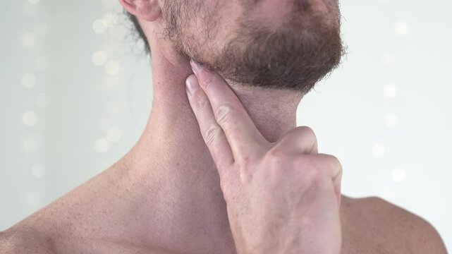 Close-up shot of a topless man feeling his carotid pulse with his fingers