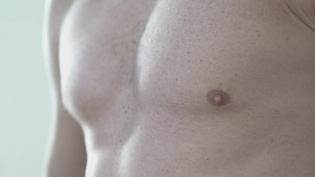 Close-up shot of a muscular male athlete revealing his pectoralis muscles