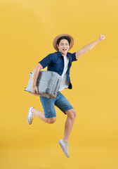 Full body image of a young Asian man wearing summer travel clothes hug the suitcase
 a suitcase posing on a yellow background